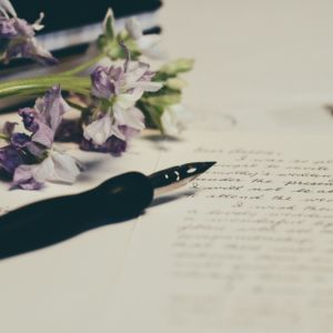 dei fiori e una penna su un foglio